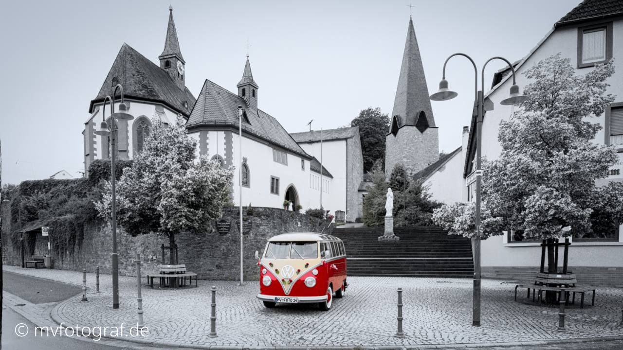 Ein roter VW Bulli steht vor der Wallfahrtskirche in Hessenthal.