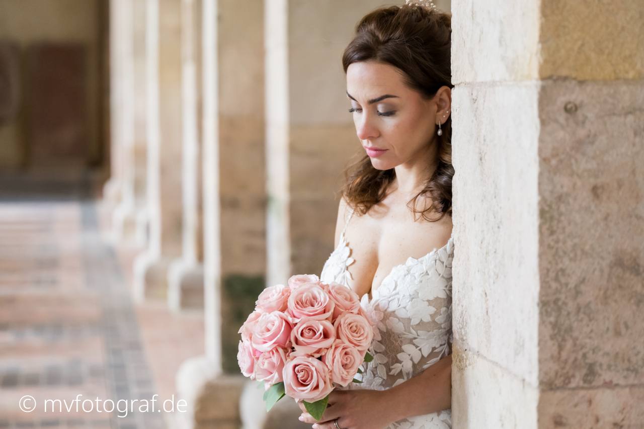Braut mit Blumenstrauss Eine Frau Land an Säulen in einer großen Kirche und liegt auf ihrem Brautstrauß
