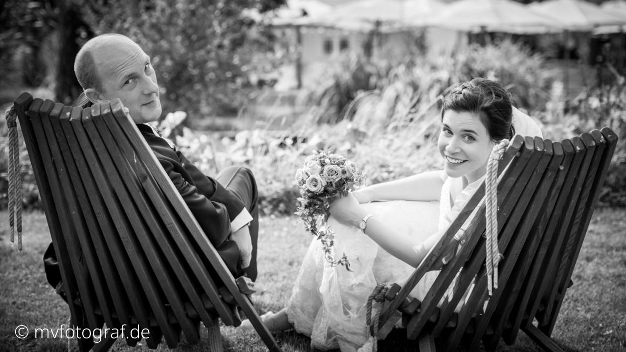 Hochzeitspaar Gartenambiente Ein Brautparr entspannt sich auf Holzliegen in einem Garten